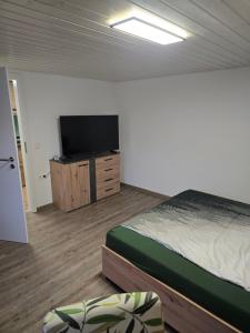 a bedroom with a bed and a flat screen tv at Ferienwohnung beim Belchen in Wieden
