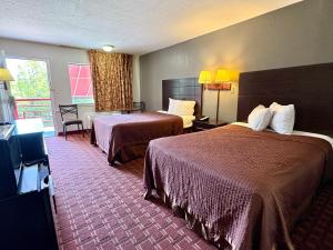 a hotel room with two beds and a television at Royal Regency Inn in Rock Hill