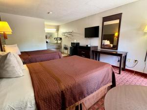 a hotel room with two beds and a mirror at Royal Regency Inn in Rock Hill
