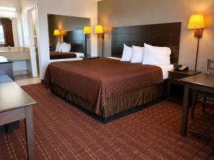 a hotel room with a large bed and a bathroom at Royal Regency Inn in Rock Hill