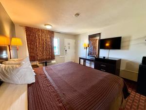 a hotel room with a bed and a flat screen tv at Royal Regency Inn in Rock Hill