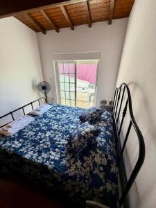 a bedroom with a bed with a blue comforter at Charming Casa Azul - Stay in Historic Chaves in Chaves