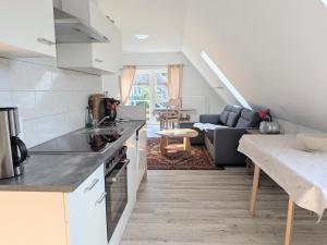 a kitchen and living room with a couch and a table at Ferienwohnung Waldblick in Fuhlendorf