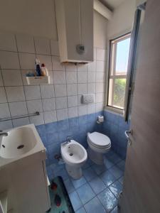 a bathroom with a white toilet and a sink at Casa Vacanze a Piazza Garibaldi in Terracina