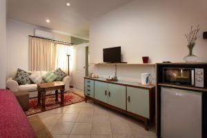 a living room with a couch and a microwave at The Old Watchmakers Guest House in Bethulie