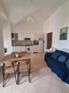 a living room with a table and a blue couch at Casa Vacanze a Piazza Garibaldi in Terracina +3 photos