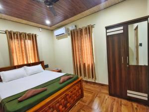 a bedroom with a bed and a mirror and a door at Shilpa Serenity in Kāsarkod