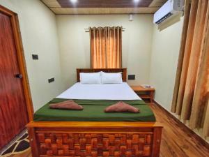 a bedroom with a bed with a green blanket at Shilpa Serenity in Kāsarkod