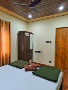 a bedroom with two beds with green sheets and a door at Shilpa Serenity in Kāsarkod