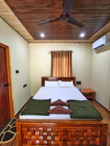 a bedroom with a large bed with a ceiling at Shilpa Serenity in Kāsarkod +15 photos