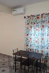 a table and chairs in a room with a curtain at Studio Cosy Mde Comores 