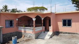 a house with a balcony in front of it at Studio Cosy Mde Comores 