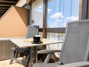 a table and chairs with a cup of coffee on it at Thermenblick in Bad Rodach