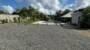 a gravel driveway in front of a house with a pool at The Resident 