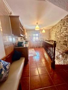 a kitchen with a couch and a stone wall at Charming Casa Azul - Stay in Historic Chaves in Chaves
