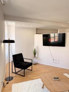 a living room with a black chair and a tv at Excellence 2 bedrooms in Saint-Pierre-le-Vieux