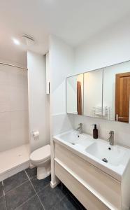 a white bathroom with a sink and a toilet at Excellence 2 bedrooms in Saint-Pierre-le-Vieux