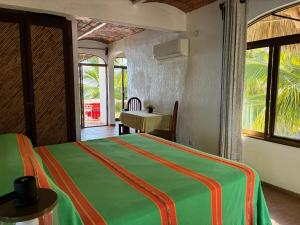a bedroom with a bed and a table and window at Bungalows Lydia San Pancho in San Francisco +76 photos