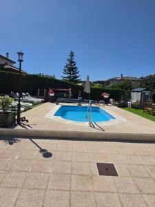 a swimming pool with a table and an umbrella at Castillo Valmoral in Burgos