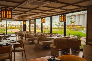 a restaurant with tables and chairs and large windows at Tauá Hotel e Convention João pessoa in João Pessoa