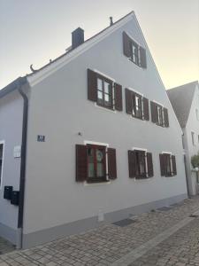 a white building with brown shuttered windows on it at Auszeit im Altmühltal in Beilngries