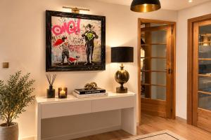 a living room with a table with a lamp and a picture at Chalet Greystone in Brides-les-Bains