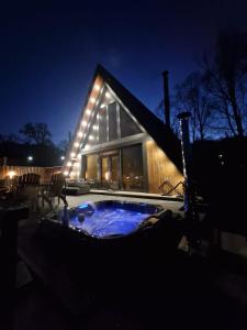 a house with a jacuzzi in the yard at night at AVA Chalet with Jacuzzi in Sinaia