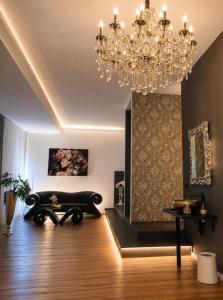 ein Wohnzimmer mit Kronleuchter und einem Tisch in der Unterkunft Privat-Spa mit Whirlpool und Sauna in Sursee in Sursee