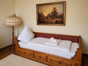 a bed with two pillows and a painting on the wall at Kurpark Suite in Bad Rodach