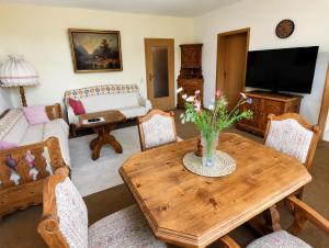 a living room with a wooden table with flowers on it at Kurpark Suite in Bad Rodach
