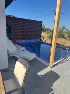 a deck with lounge chairs and a swimming pool at Villa Metehan in Kumluca