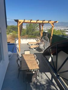a patio with a wooden table and chairs on a balcony at Villa Metehan in Kumluca