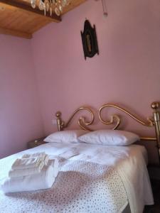 a bedroom with pink walls and a bed with white pillows at Casa vacanza da GIGI in Calascio