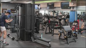 a man standing in a gym looking at his cell phone at Hotel El Nogal in Peligros