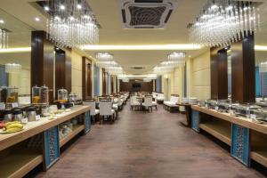 a restaurant with tables and chairs and chandeliers at Kalinga Hotel in Jodhpur
