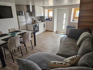 a living room with a couch and a table and a kitchen at Gîte MARS in Torcenay