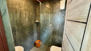 a bathroom with a shower and two toilets in it at CASANADA Sea View Suite in Malpe
