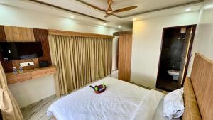 a bedroom with a white bed and a toilet at CASANADA Sea View Suite in Malpe