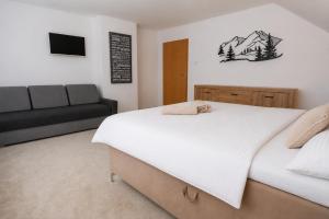 a bedroom with a large bed and a couch at Apartmánový dom Adriana in Zuberec