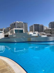 a large swimming pool with buildings in the background at Caesar Resort spa in Dherinia