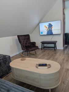 a living room with a table and a chair at Le Pignon Douillet in Sainte-Anne-des-Monts
