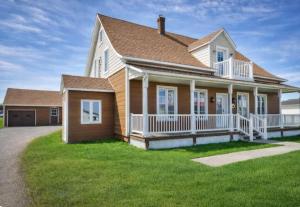 a large house with a large front yard at Le Pignon Douillet in Sainte-Anne-des-Monts