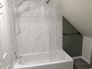 a bathroom with a shower and a white tub at Le Pignon Douillet in Sainte-Anne-des-Monts +18 photos