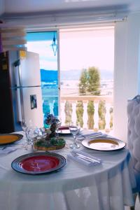 a white table with plates and wine glasses on it at Apartamento THEMIS Tocancipa in Bemposta