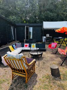 a yard with a group of chairs and a tent at Farmstay cabin firepit & activities in Hertford