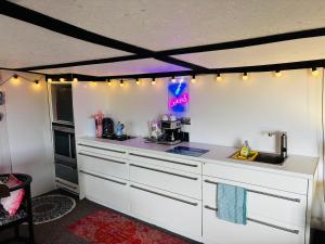 a kitchen with white cabinets and a counter top at Farmstay cabin firepit & activities in Hertford