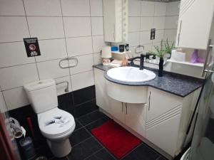 a bathroom with a white toilet and a sink at Red House Retreat Aegina Kontos in Kondós +22 photos