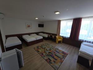 a room with three beds and a tv in it at Penzion PKO Nitra in Nitra +57 photos