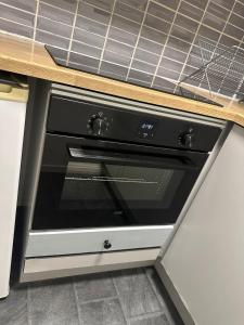 a black oven sitting under a counter in a kitchen at Fantastic Apartment Tromsø Two in Tromsø +15 photos