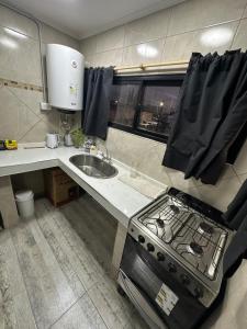 a small kitchen with a stove and a sink at Lo de jota in Ramallo